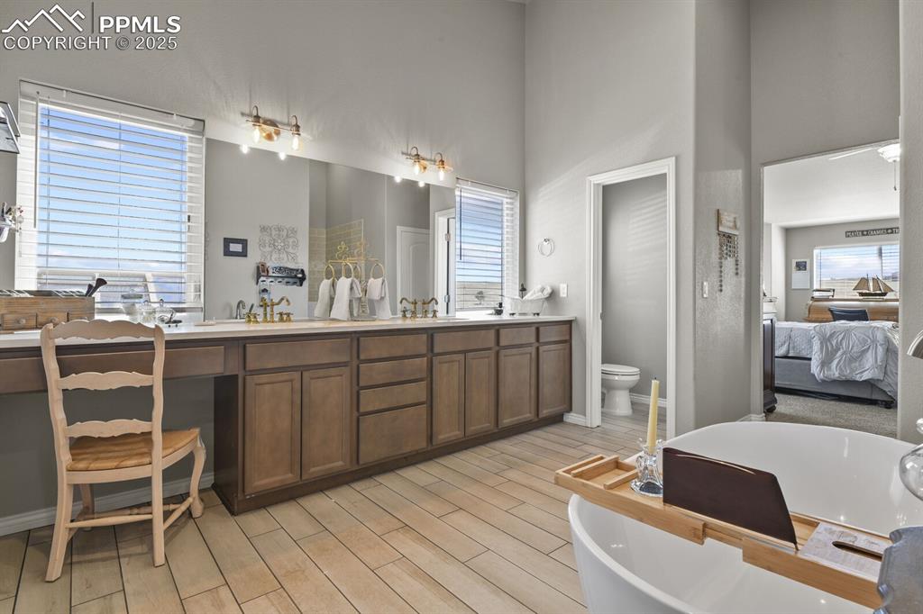 Image 17 of 49: Bathroom with double sink, a bathing tub, a wealth of natural light, and la