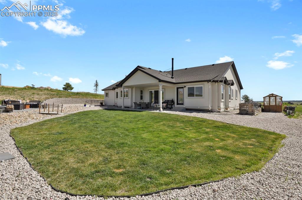 Image 37 of 49: Rear view of house featuring a patio and landscaping