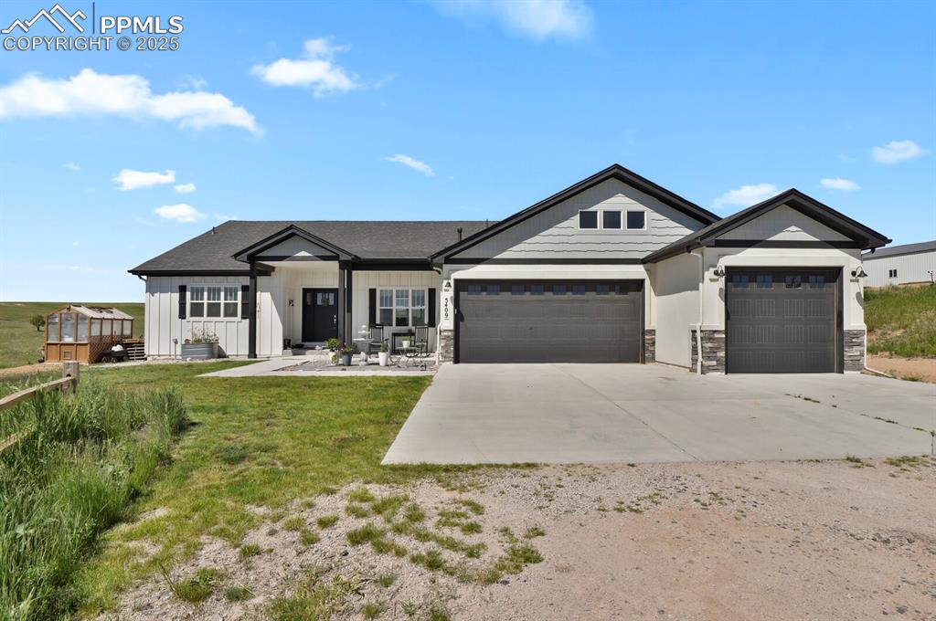 Image 4 of 49: View of front of house with a front yard and a garage