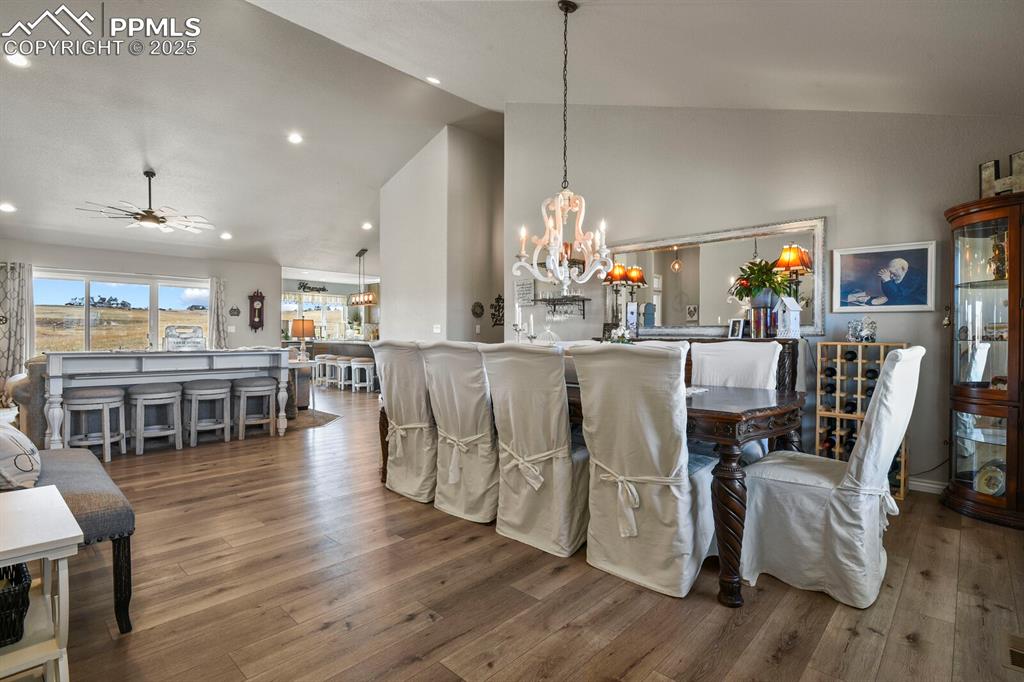 Image 8 of 49: Dining area featuring high vaulted ceiling, wood-type flooring, and ceiling