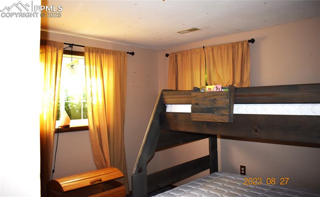 Image 26 of 48: Traditional bedroom with garden level escape windows. 