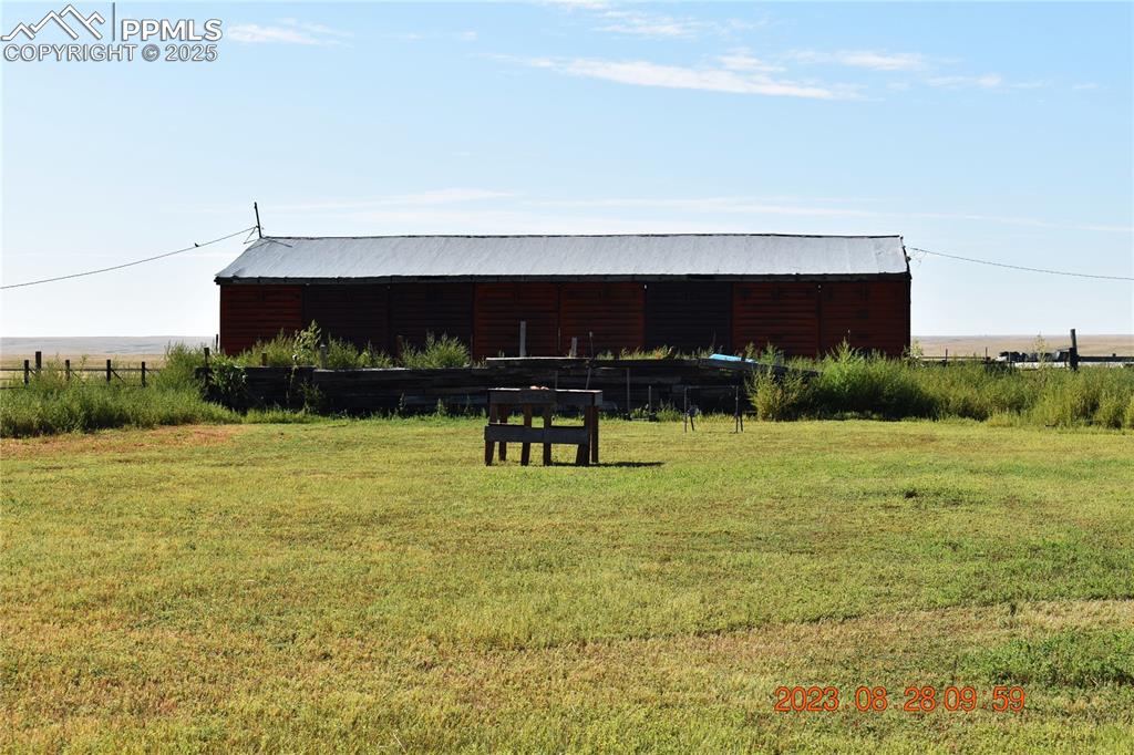 Image 35 of 48: Barn made of the end walls of train cars.  In front of the barn is a shooti