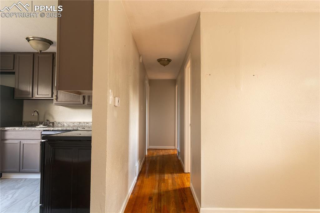 Image 10 of 44: Hallway with baseboards and wood finished floors