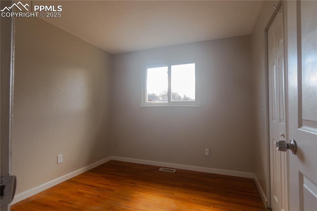 Image 11 of 44: Spare room featuring wood finished floors and baseboards
