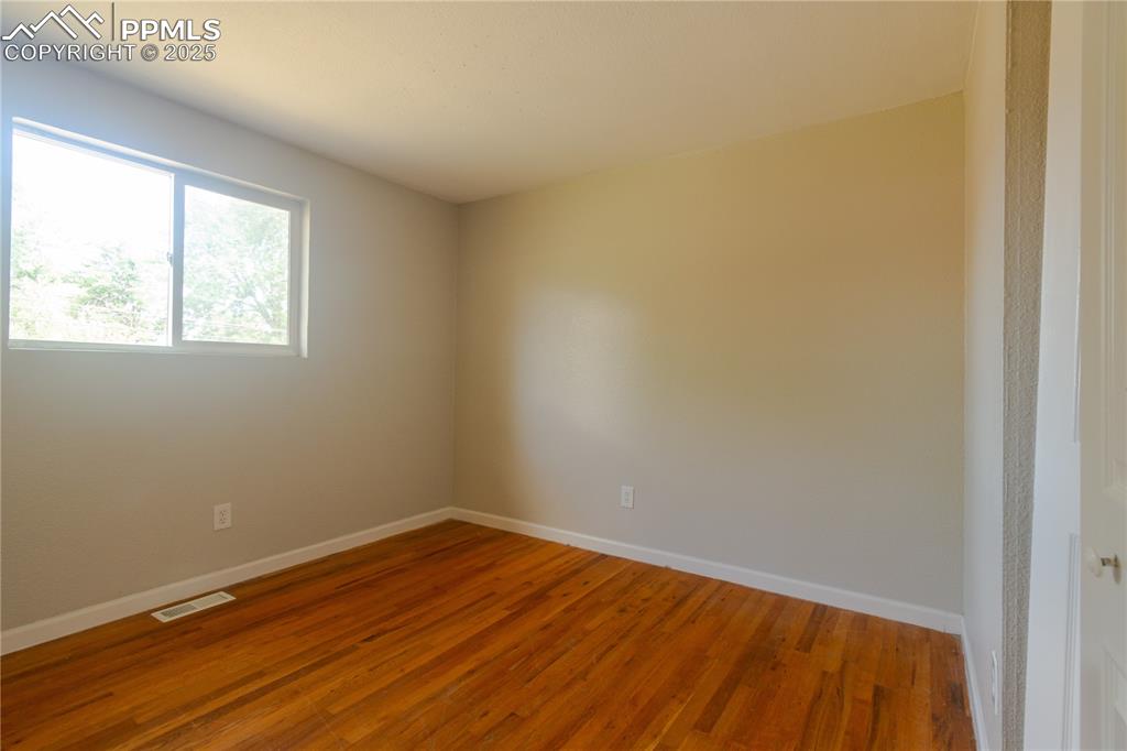 Image 19 of 44: Spare room featuring baseboards and wood finished floors