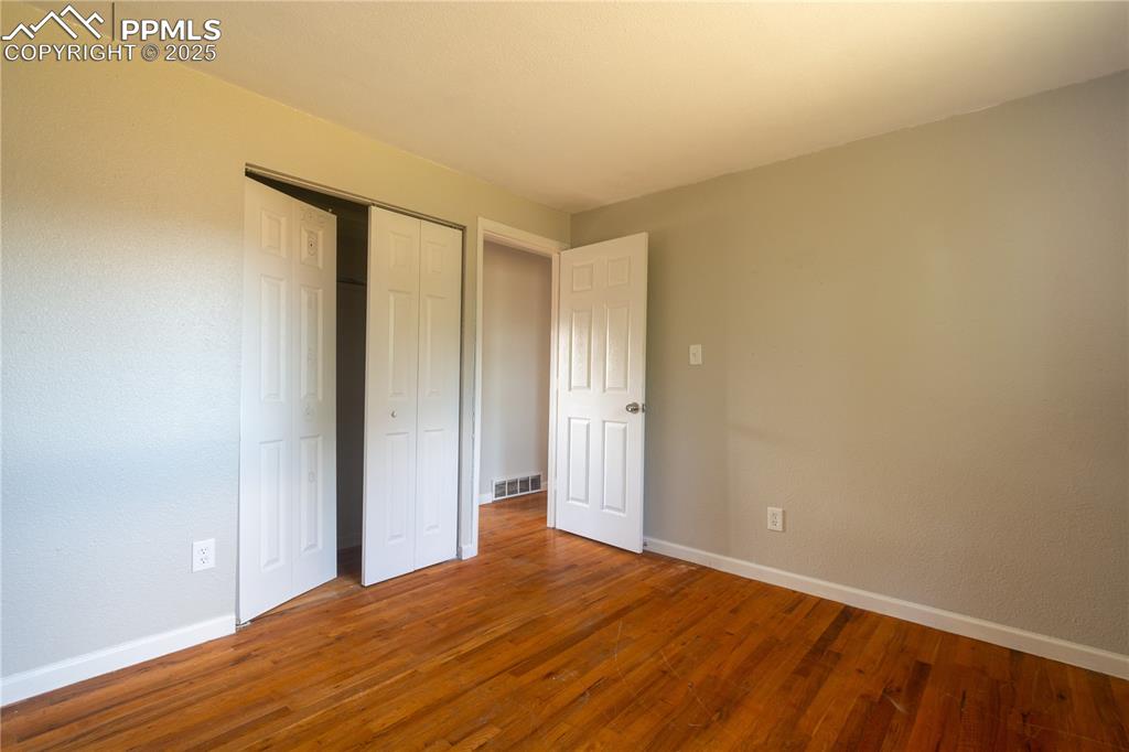 Image 21 of 44: Unfurnished bedroom with wood finished floors and a closet