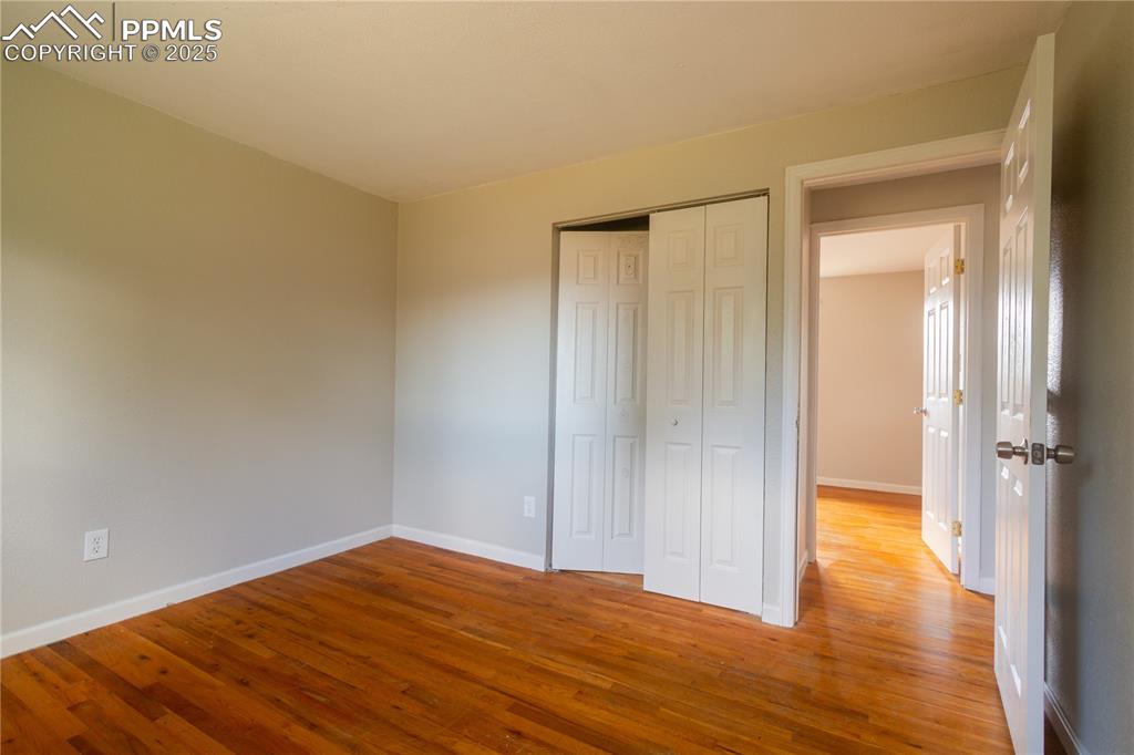 Image 22 of 44: Unfurnished bedroom featuring wood finished floors and a closet