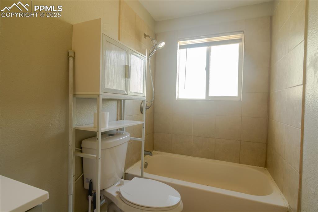 Image 24 of 44: Bathroom featuring washtub / shower combination and vanity