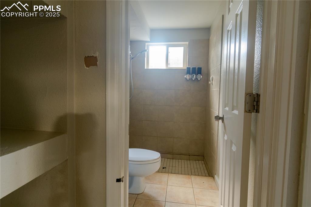 Image 39 of 44: Bathroom featuring a shower stall and tile patterned flooring