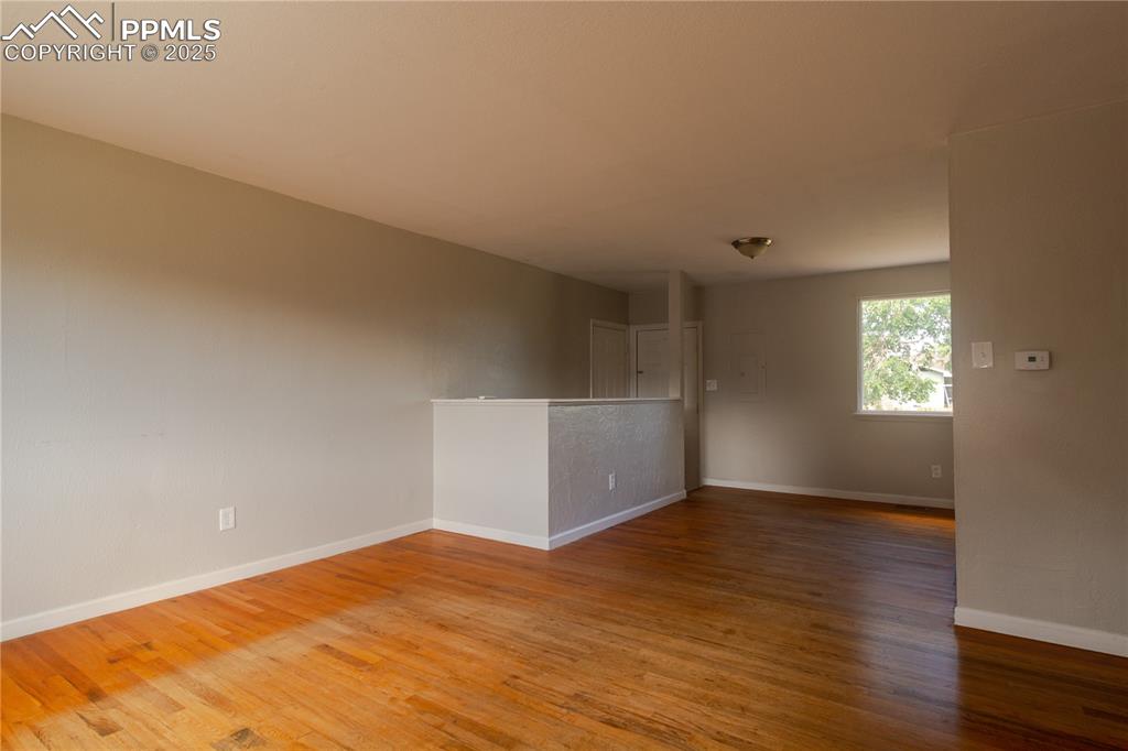 Image 5 of 44: Empty room featuring wood finished floors and baseboards
