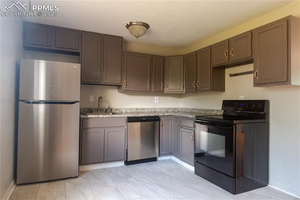 Image 9 of 44: Kitchen with appliances with stainless steel finishes and light countertops