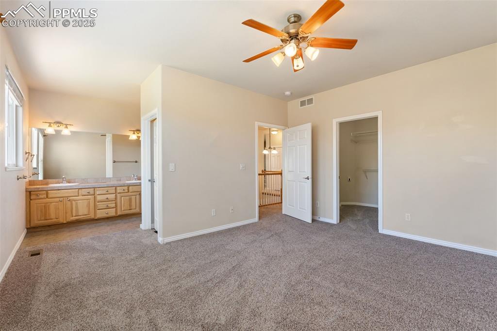 Image 13 of 50: Unfurnished bedroom with light colored carpet, a spacious closet, a ceiling
