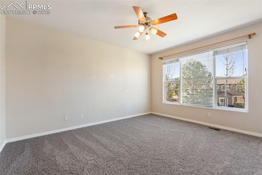 Image 16 of 50: Carpeted spare room featuring baseboards and ceiling fan