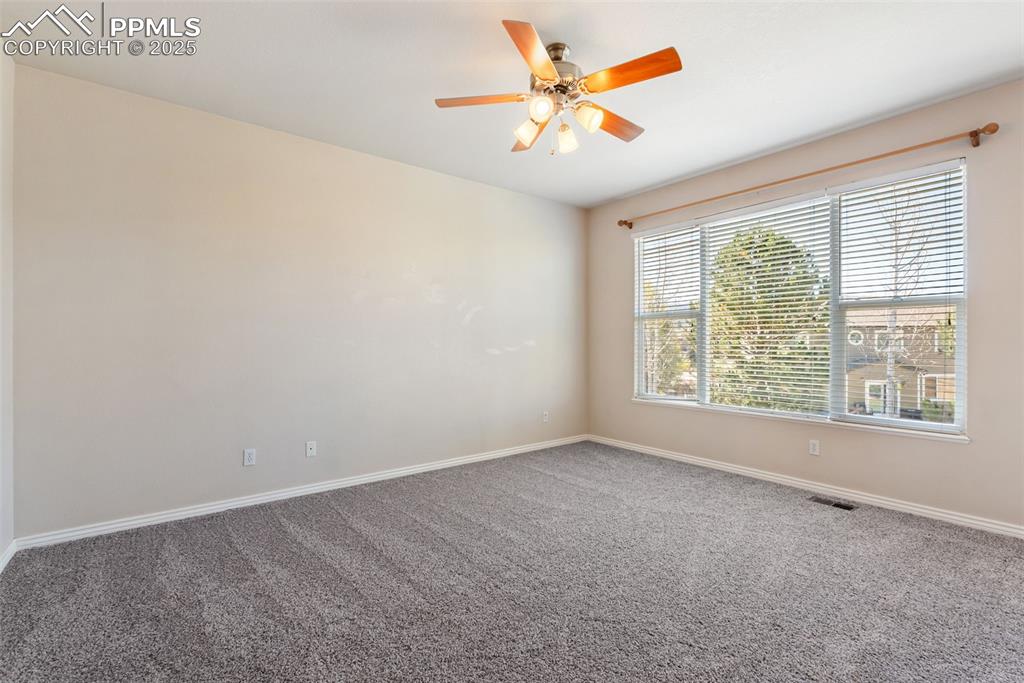 Image 18 of 50: Carpeted spare room featuring baseboards and a ceiling fan