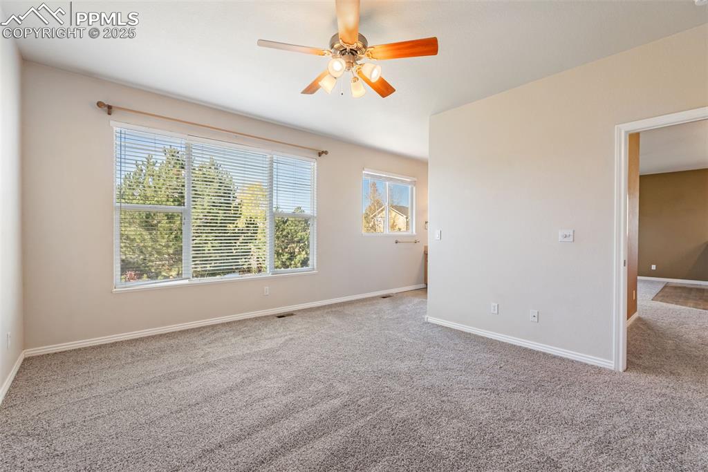 Image 19 of 50: Carpeted spare room with baseboards and ceiling fan