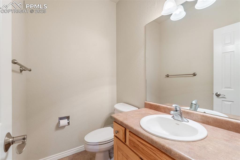 Image 23 of 50: Half bath with tile patterned floors and vanity