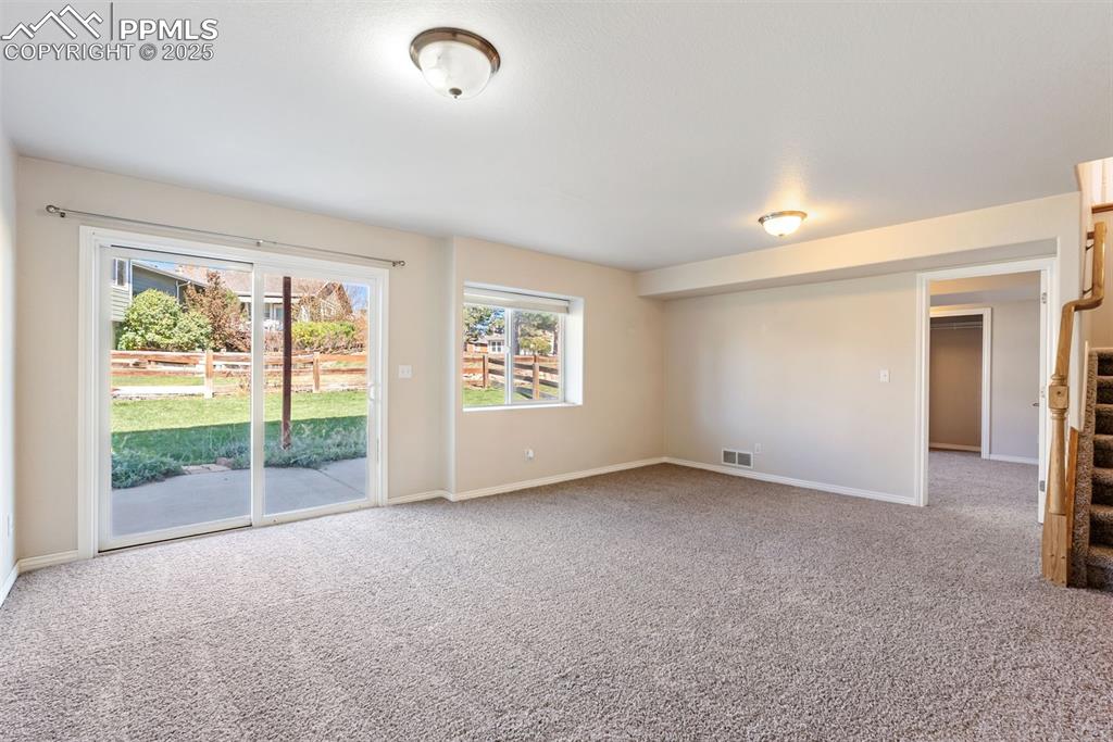 Image 25 of 50: Empty room featuring plenty of natural light and light colored carpet