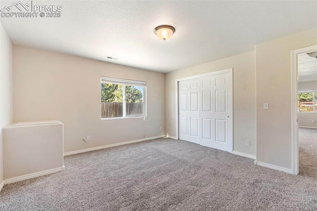 Image 29 of 50: Unfurnished bedroom with carpet flooring and a closet