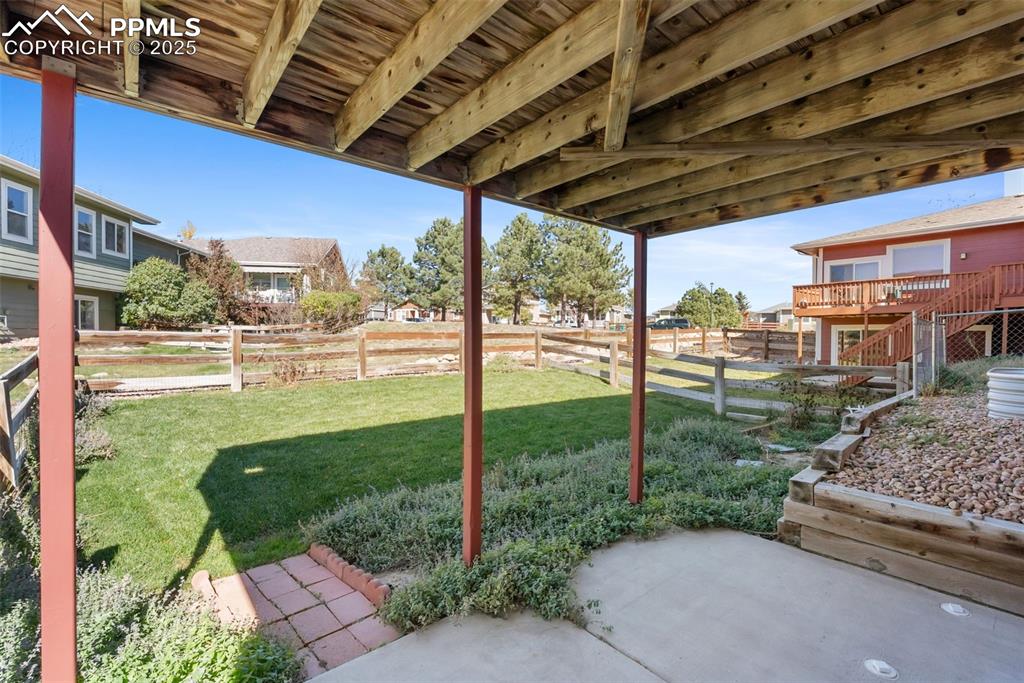 Image 39 of 50: Fenced backyard featuring a deck and a patio area