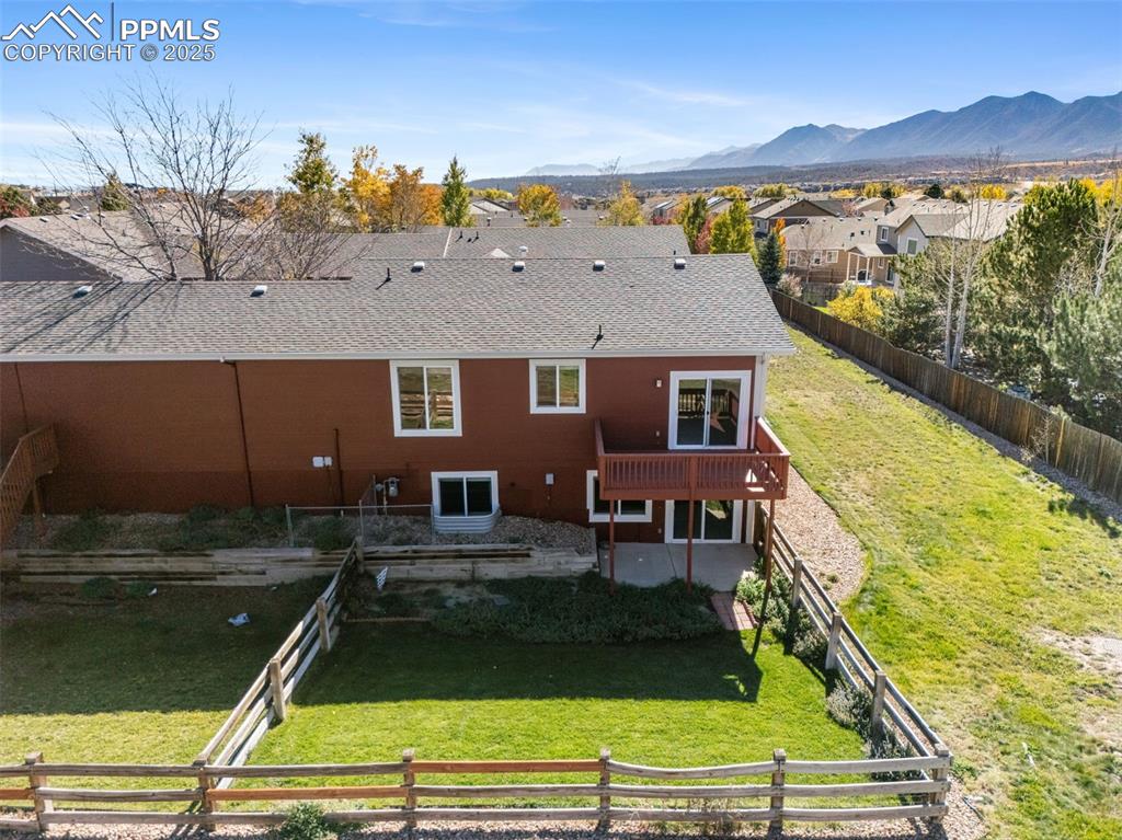 Image 45 of 50: Back of property with a fenced backyard, roof with shingles, a residential