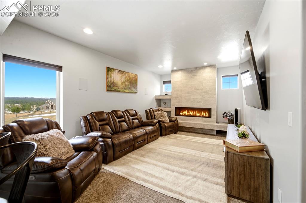 Image 16 of 48: Living room featuring carpet flooring, a fireplace, and recessed lighting