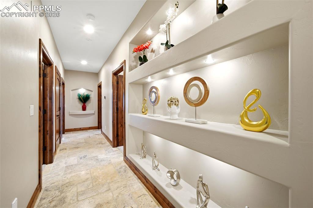 Image 24 of 48: Hallway featuring stone tile floors and baseboards