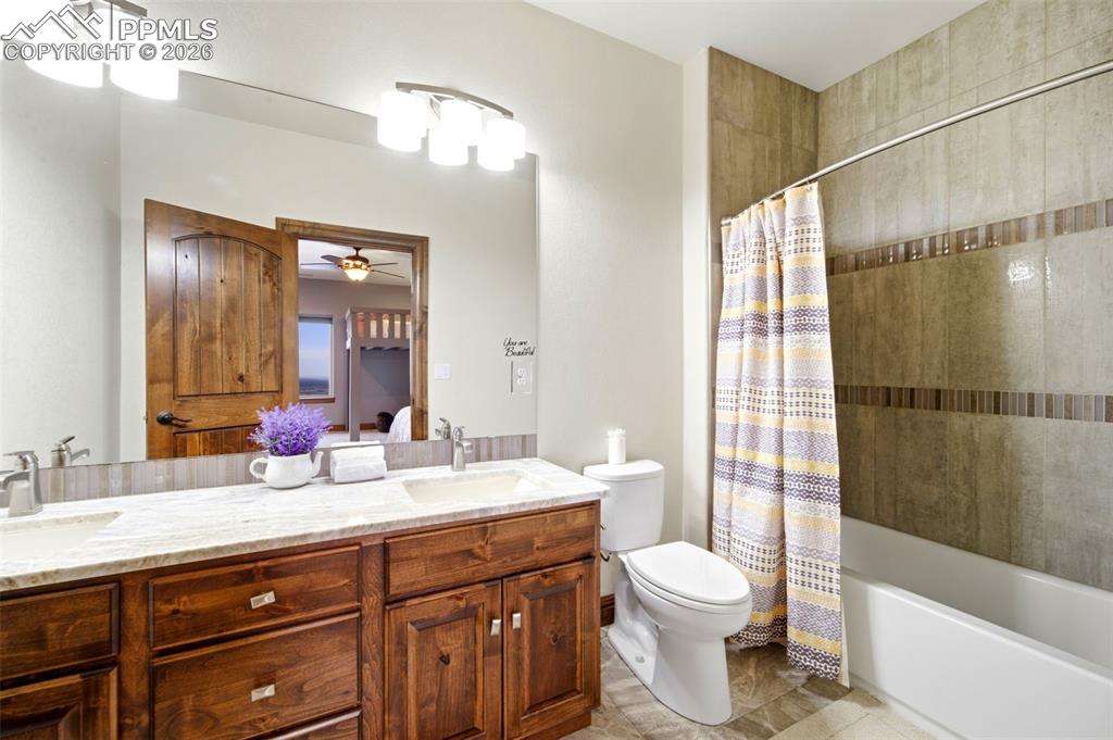 Image 30 of 48: Bathroom with double vanity, ceiling fan, shower / bath combo, and ensuite