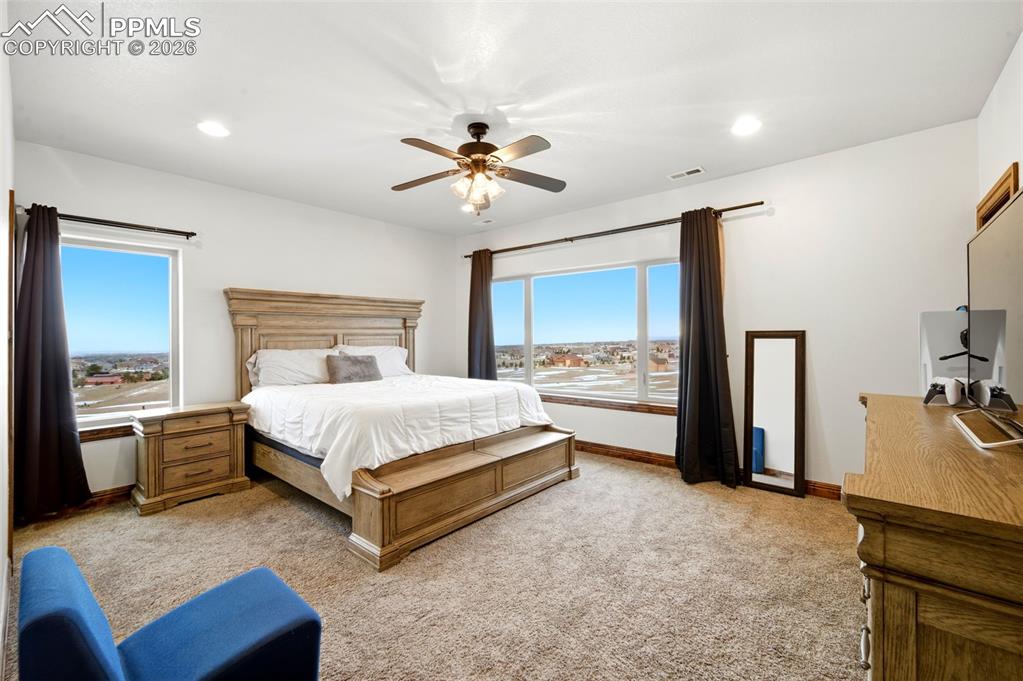 Image 31 of 48: Bedroom with a ceiling fan, light carpet, recessed lighting, and multiple w