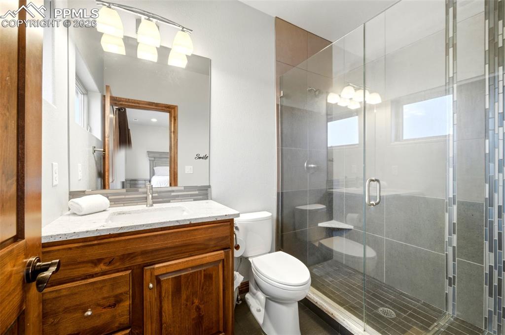 Image 32 of 48: Full bath with vanity, a shower stall, ensuite bath, and healthy amount of