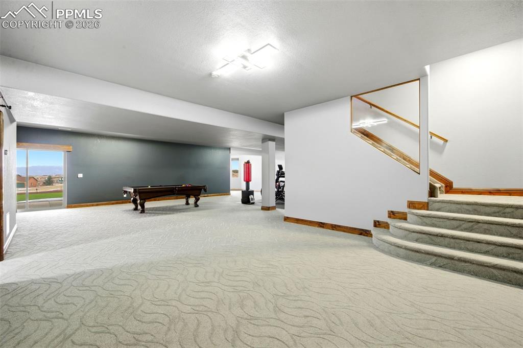 Image 33 of 48: Recreation room featuring light colored carpet, billiards table, and a text