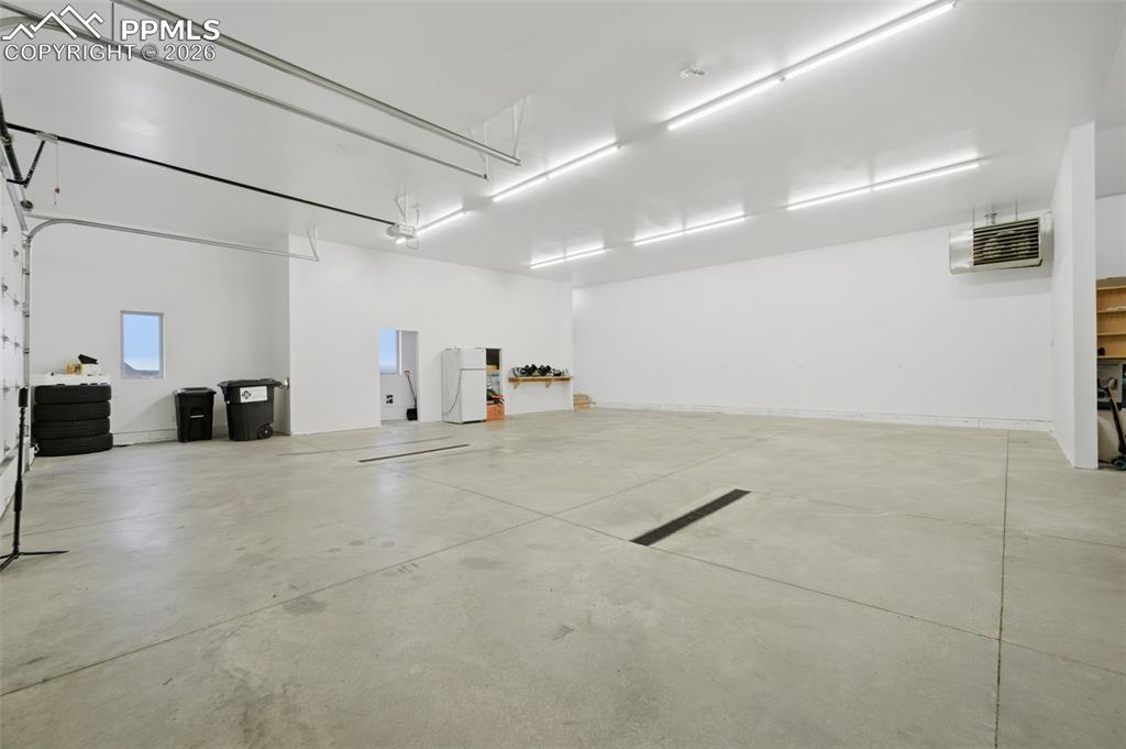 Image 41 of 48: Garage featuring freestanding refrigerator and a heating unit