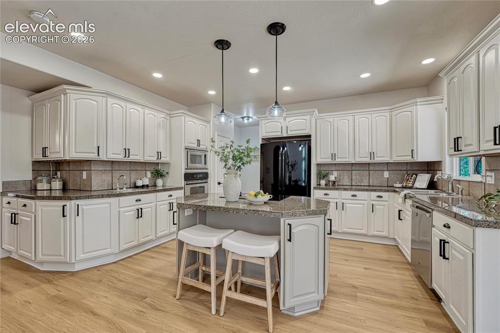Image 20 of 49: Spacious eat-in kitchen with island...