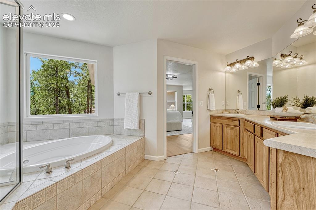 Image 29 of 49: Adjoining 5-piece bath with double vanity, soaker tub...