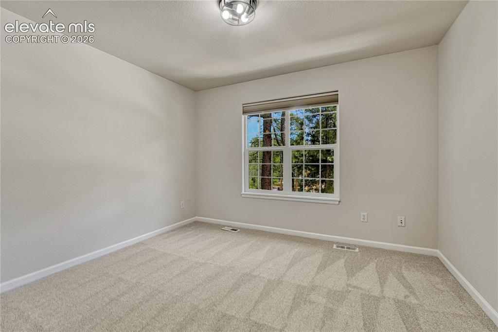 Image 33 of 49: First of two additional upstairs bedrooms.