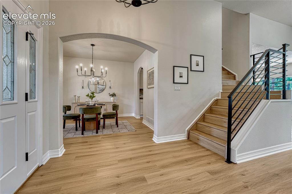 Image 8 of 49: New metal stair rail and arched entries to the formal dining room.