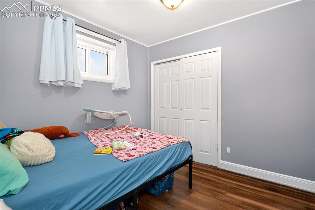 Image 11 of 20: Bedroom featuring wood finished floors, a closet, and ornamental molding