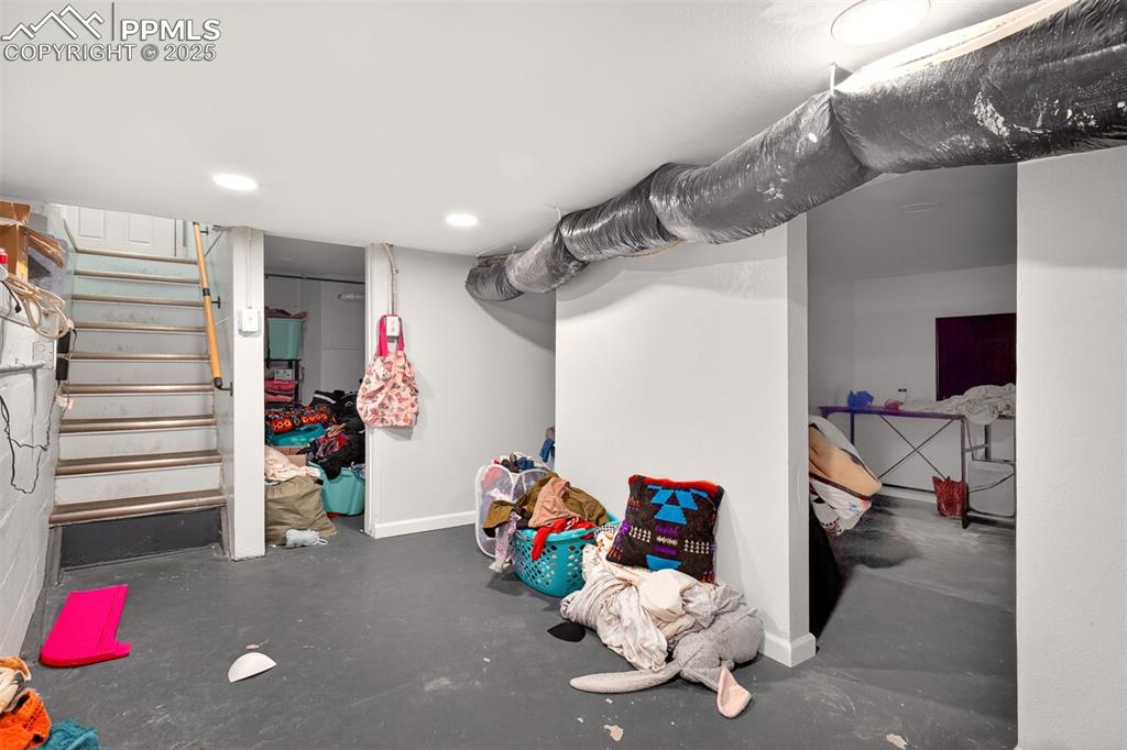 Image 14 of 20: Finished basement featuring stairway and recessed lighting