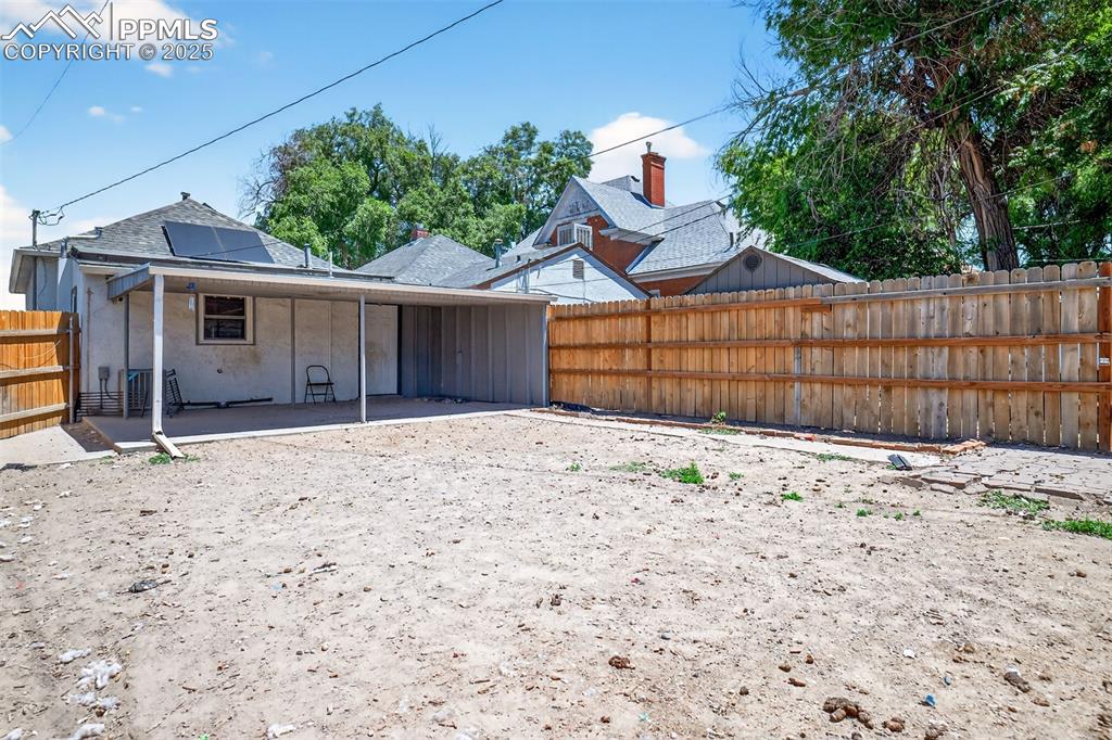 Image 17 of 20: Back of property featuring a patio area, a fenced backyard, solar panels, s