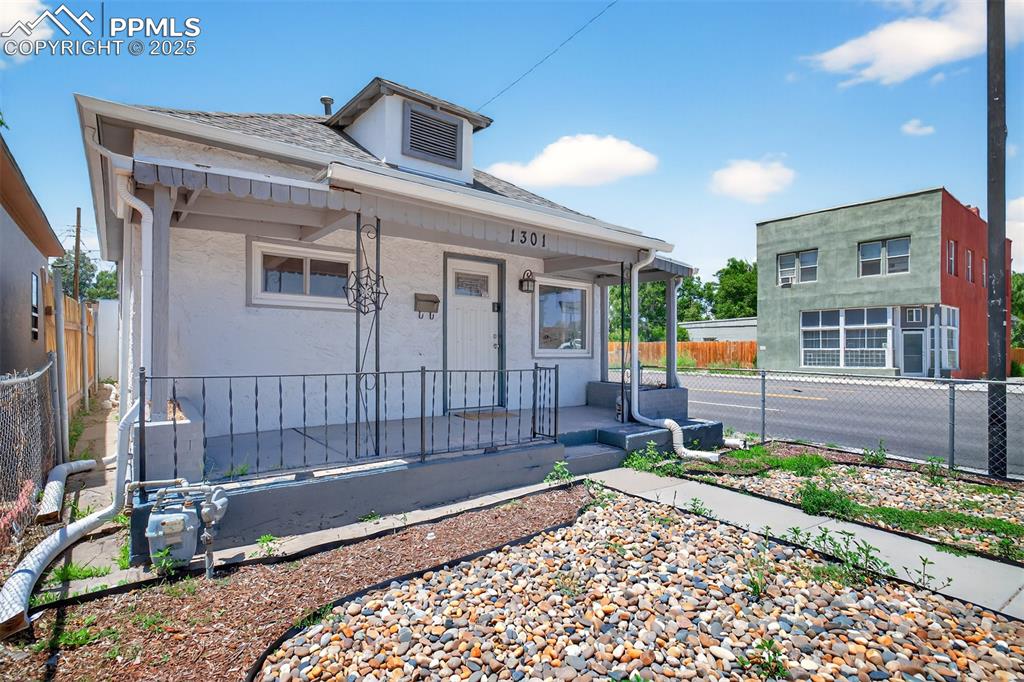 Image 19 of 20: Bungalow with covered porch, a shingled roof, and stucco siding