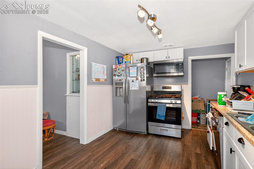 Image 2 of 20: Kitchen featuring stainless steel appliances, dark wood finished floors, a