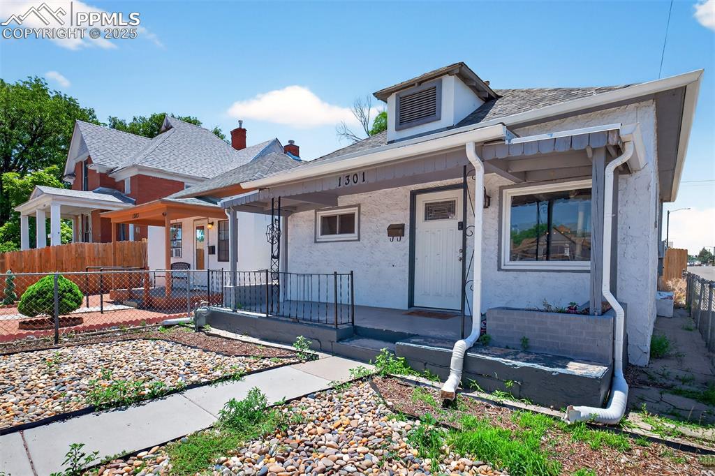 Image 20 of 20: View of front facade featuring a porch, stucco siding, and a shingled roof