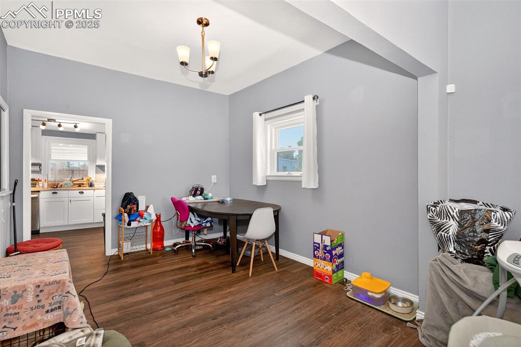 Image 5 of 20: Dining area featuring dark wood-type flooring and a chandelier