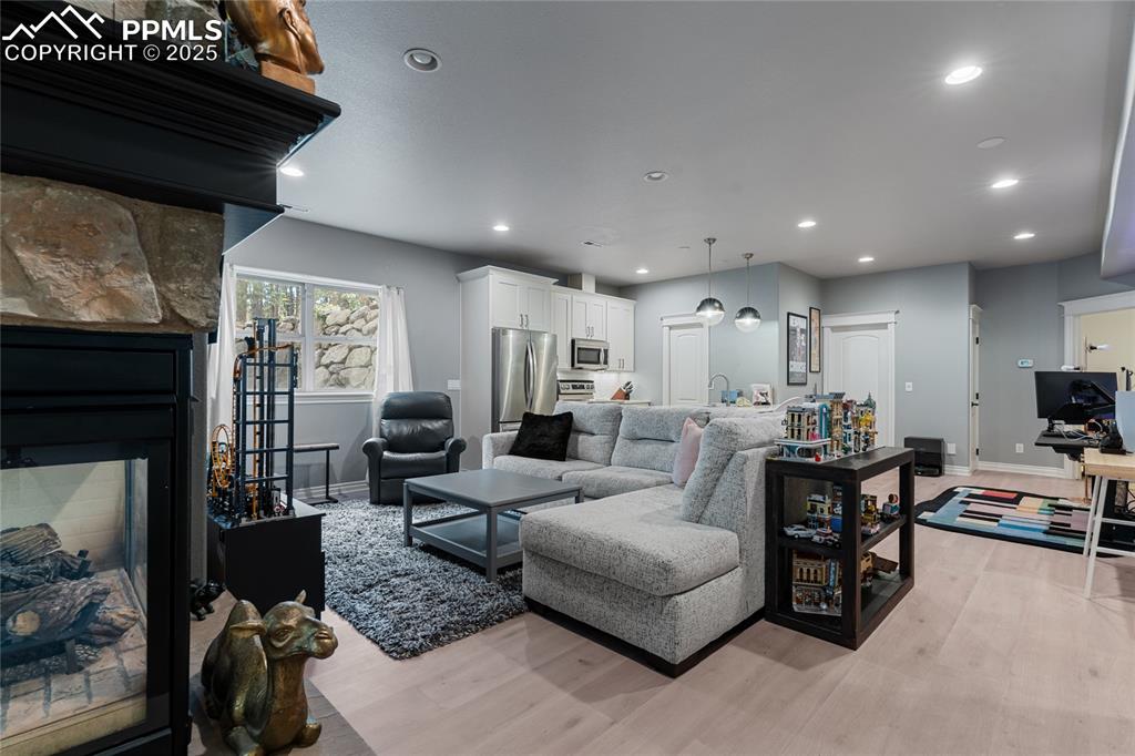 Image 34 of 46: The dual sided fireplace seperates the golf/media space from another large 