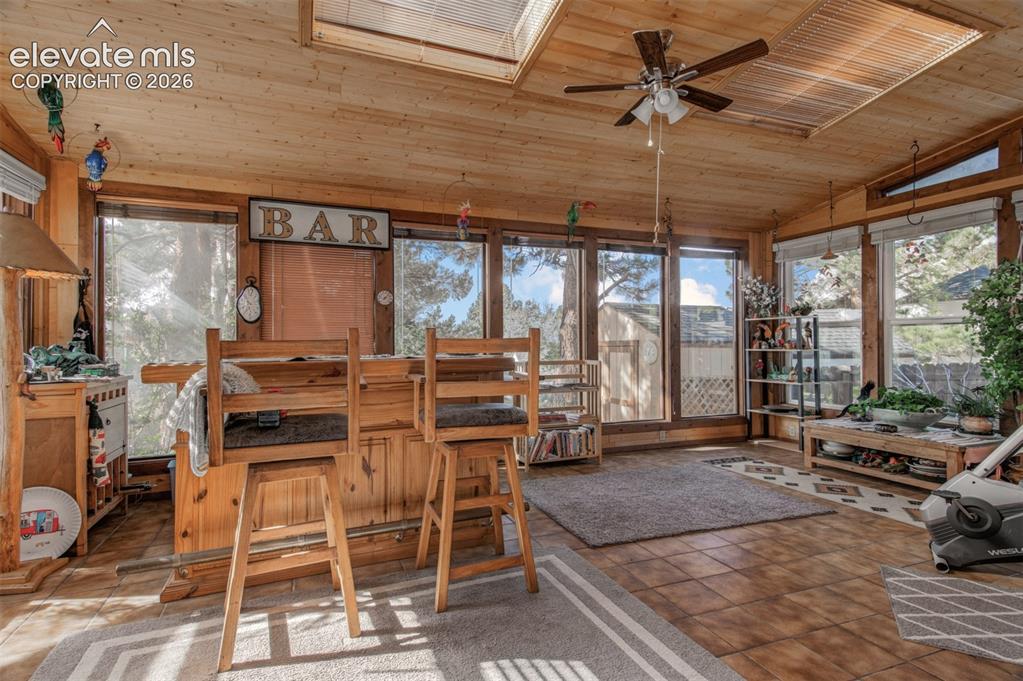 Image 14 of 45: Wood-paneled ceiling with a built-in ceiling fan, skylights, and multiple l