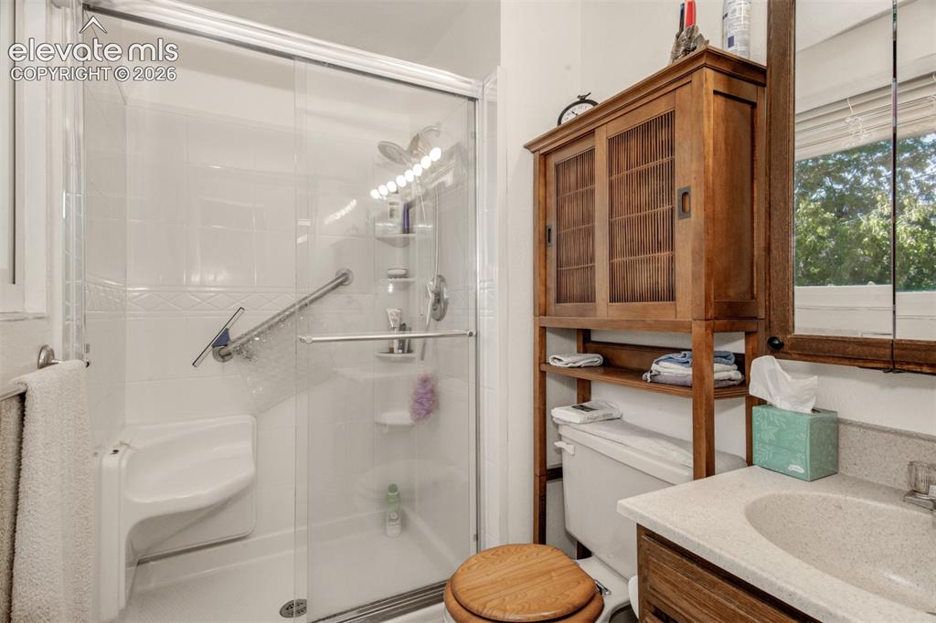 Image 19 of 45: Spa-inspired bathroom featuring a frameless glass-enclosed shower with inte