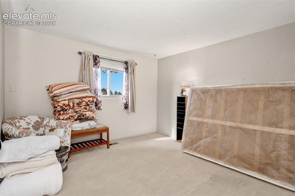 Image 21 of 45: Bedroom two; Wall-to-wall carpeting with light-colored walls and a window w