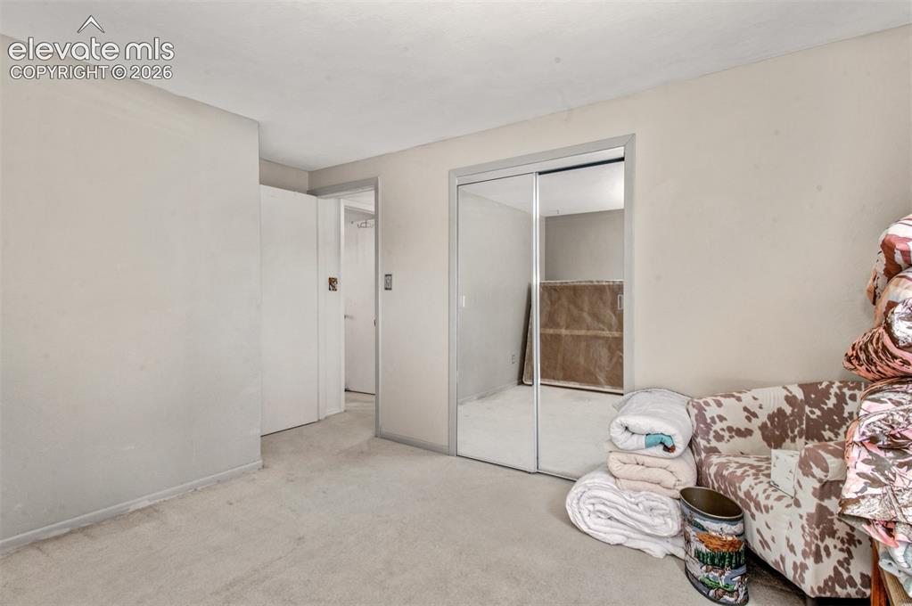 Image 22 of 45: Bedroom two:Mirrored closet doors and neutral carpeting