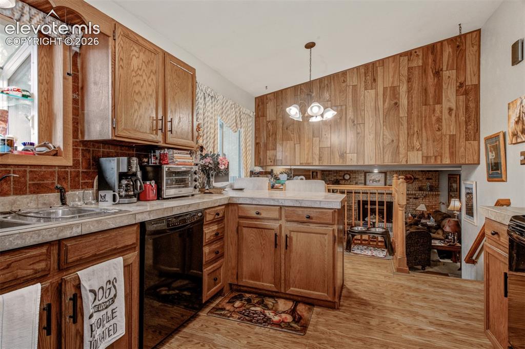 Image 3 of 45: Kitchen featuring wood-finish flooring, wood cabinetry, L-shaped counter sp