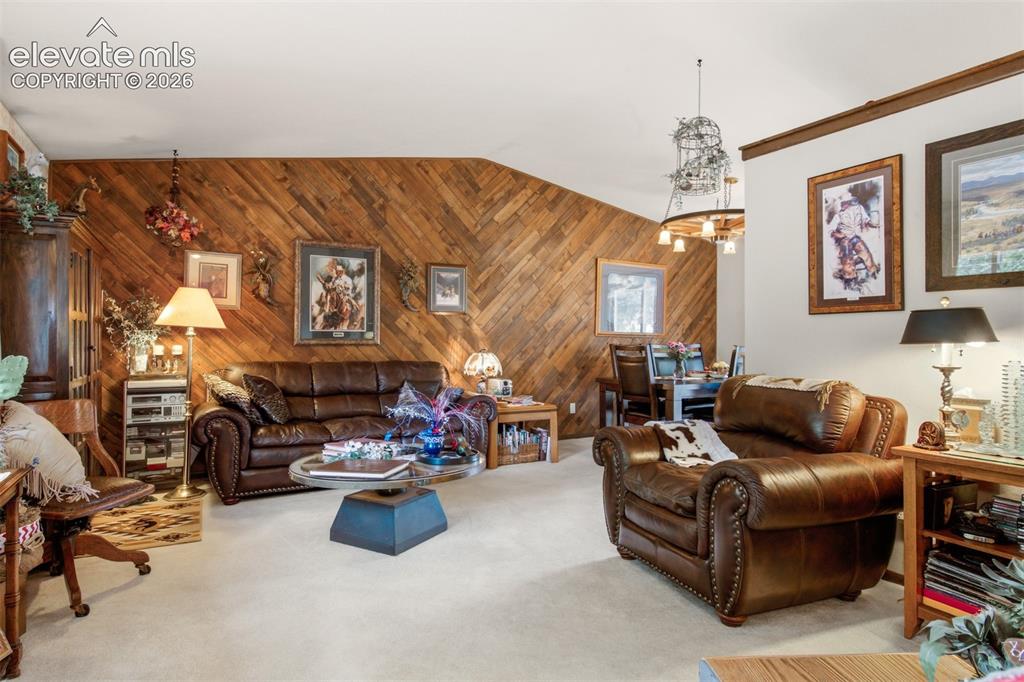 Image 5 of 45: Vaulted ceiling and diagonal wood-paneled accent wall in this comfortable L