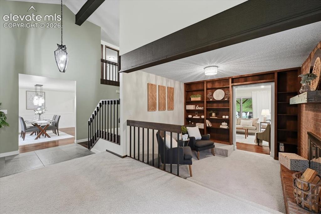Image 10 of 50: Living Room leads to Dedicated Den. Built ins and Gas Fireplace